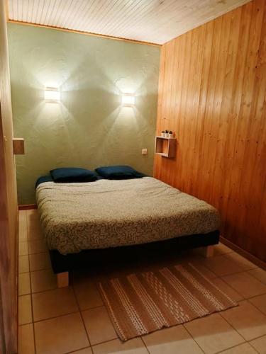 une chambre avec un lit avec deux oreillers bleus dans l'établissement Gîte Cœur de Haute-Savoie, à Viuz-en-Sallaz
