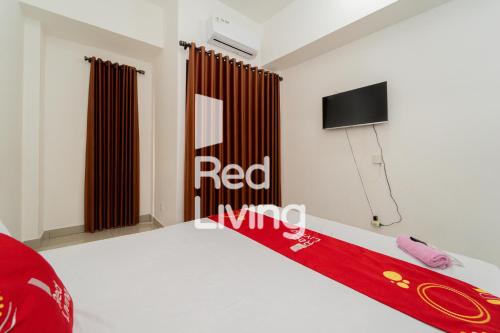 - une chambre avec une couverture rouge sur un lit dans l'établissement RedLiving Apartemen Sayana - Sentra Jaya, à Bekasi