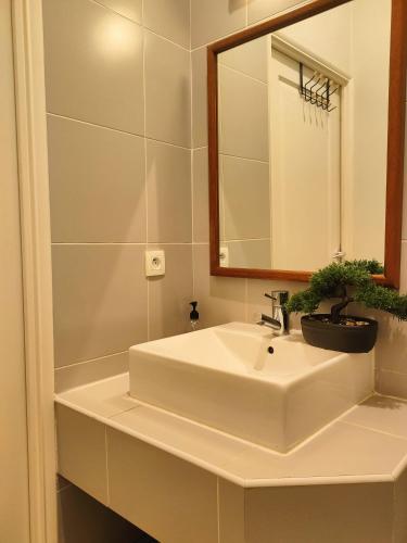 une salle de bain avec un lavabo blanc et un miroir dans l'établissement Appartemment RUE DE LA REPUBLIQUE, joli et moderne au coeur du centre, à Marseille