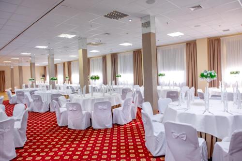 a banquet hall with white tables and chairs at Hotel 500 in Tarnowo Podgórne