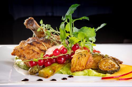 a plate of food with meat and vegetables on a table at Hotel 500 in Tarnowo Podgórne