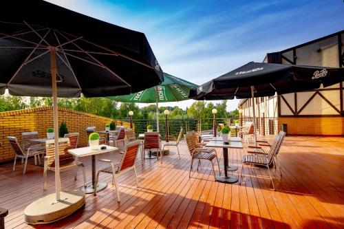 a patio with tables and chairs and umbrellas at Hotel 500 in Tarnowo Podgórne
