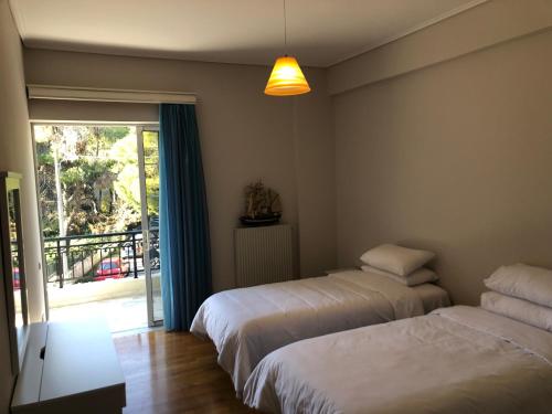 2 camas en una habitación de hotel con balcón en Zack's Grande en Atenas