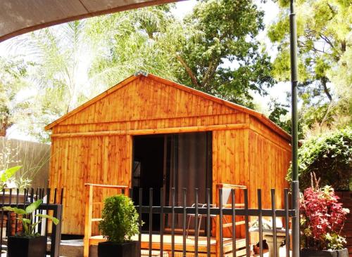 波羅克瓦尼的住宿－ZUCH Accommodation at Pafuri Self Catering - Guest Cabin，前面有栅栏的木棚
