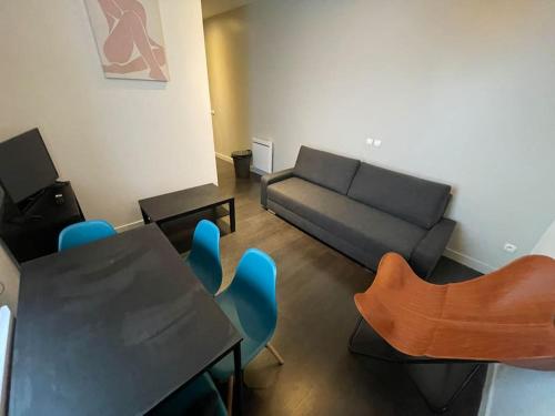 un salon avec un canapé, une table et des chaises dans l'établissement Cosy appartement 3 hypercentre, à Lille