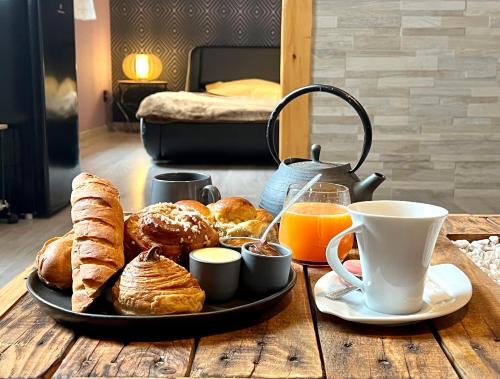 a tray of pastries and coffee on a wooden table at * La Maisonette * avec Sauna & Hammam privatifs in Nevers