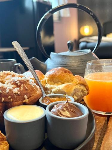 * La Maisonette * avec Sauna & Hammam privatifs في نيفير: صينية من المعجنات وكوب من عصير البرتقال