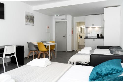 Cette chambre comprend 3 lits, une table et une cuisine. dans l'établissement Almada Downtown 103, à Porto