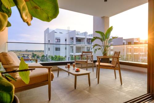 a living room with furniture and a large window at Sunset Gardens in Limassol