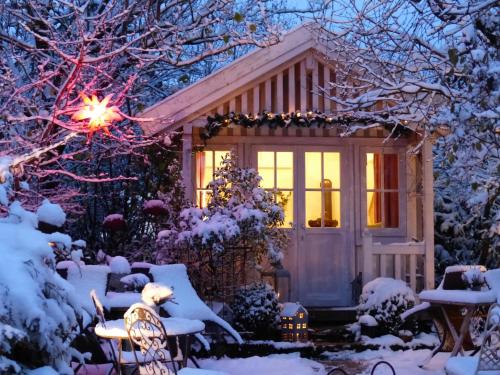 ein Haus mit Weihnachtslichtern im Schnee in der Unterkunft WERTS HOF FerienWohnen in Rauschenberg