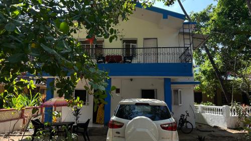 a white car parked in front of a house at Muffys Guest House in Arpora