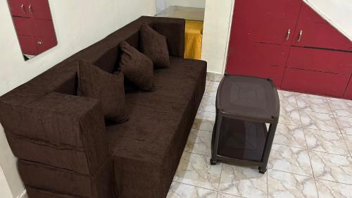 a brown couch with a tv sitting on the floor at Muffys Guest House in Arpora