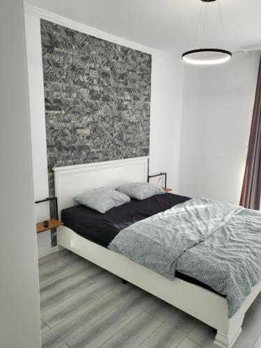 a bedroom with a bed and a wall at Dacrilo Apartments Cluj-Napoca 11 in Cluj-Napoca