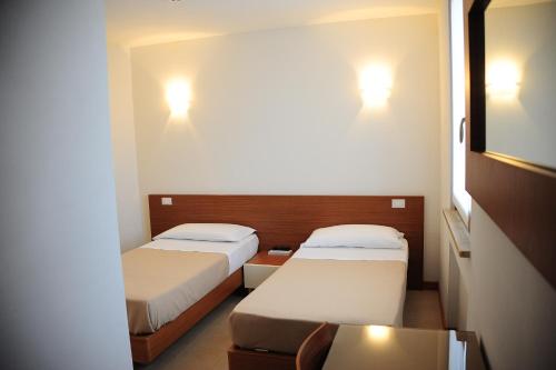 Habitación pequeña con 2 camas y 2 luces en Suite Maria, en Buttrio