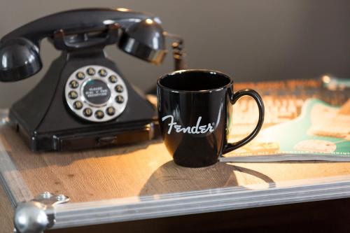 a coffee cup sitting on a table next to a telephone at Hotel Indigo - Cardiff by IHG in Cardiff