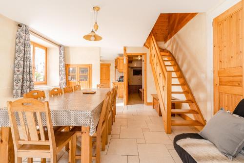 une salle à manger avec une table et des chaises et un escalier dans l'établissement Gîte des Cascades, à Sixt-Fer-à-Cheval