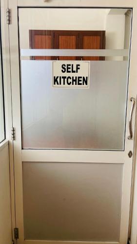 a sliding glass door with a self kitchen sign on it at Ama Residence in Matale