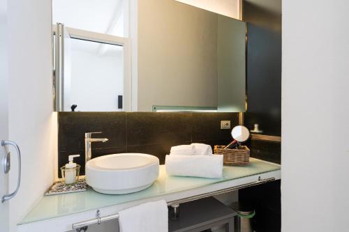 La salle de bains est pourvue d'un lavabo et d'un miroir. dans l'établissement Vittorio Veneto by Bed&Bros, à Syracuse