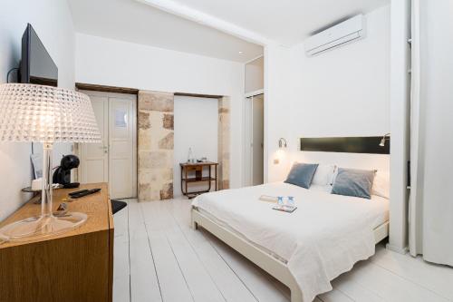1 dormitorio con 1 cama y escritorio con lámpara en Vittorio Veneto by Bed&Bros, en Siracusa