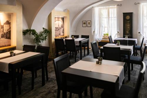 a restaurant with tables and chairs in a room at Hotel Bílá Paní in Jindrichuv Hradec