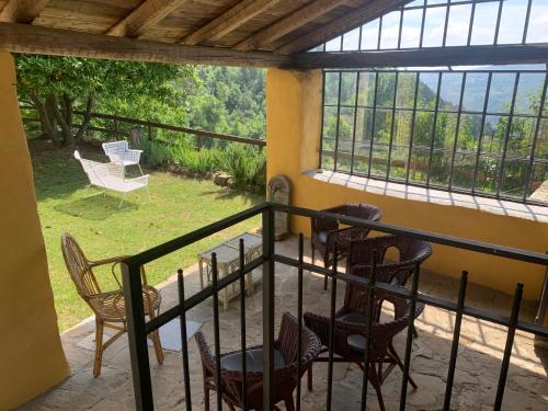 a balcony with chairs and a table and windows at Agriturismo La Collina degli Scoiattoli in Cravanzana