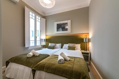 a bedroom with two beds and a window at Habitat Apartments Barcelona Classic in Barcelona