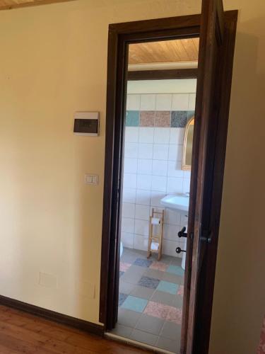 a door leading to a bathroom with a sink at Agriturismo La Collina degli Scoiattoli in Cravanzana