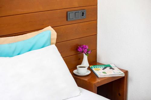 a bed with a table with a vase and a book at Mare Nostrum in Kas