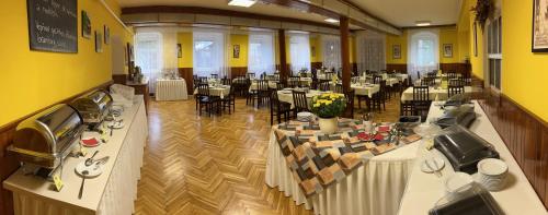 a large banquet hall with tables and chairs at Hotel Slatina in Lipova Lazne