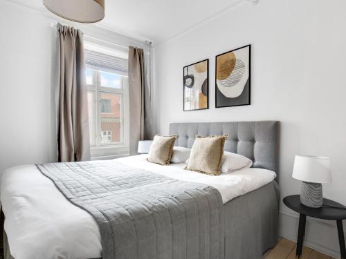 Un dormitorio con una cama grande y una ventana en Sanders Stage - Charming Three-Bedroom Apartment Near Nyhavn, en Copenhague