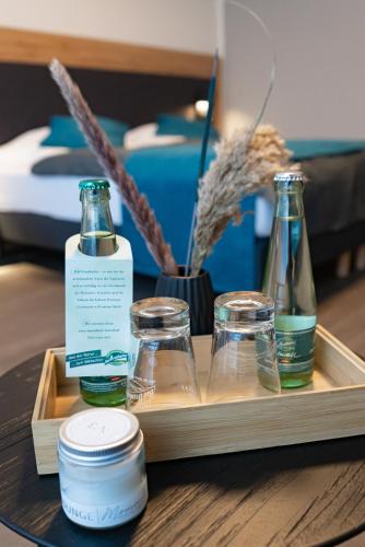 a tray with three bottles on a table at Villa & Hotel Am Park in Reichenbach im Vogtland