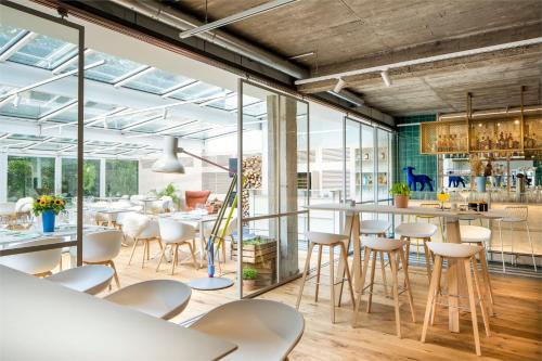 een restaurant met witte tafels en stoelen en grote ramen bij Fettehenne Gästehaus in Erkrath