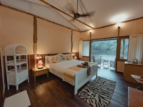 1 dormitorio con cama y ventana grande en Rukhad Jungle Camp - Pench, 