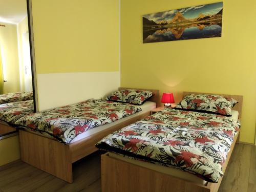 a room with two beds and a mirror at Apartments Košević in Osijek