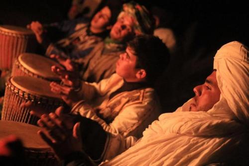 a group of people sitting in a crowd in a theater at Khadija Desert Camp in Merzouga