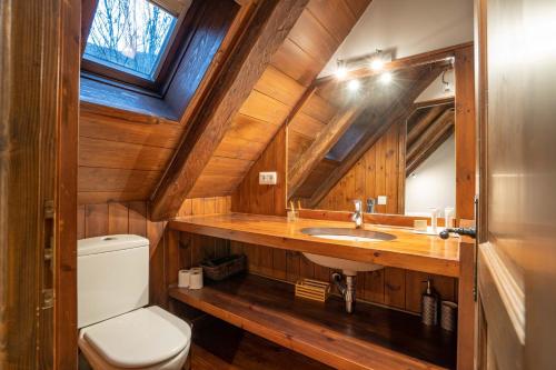 a bathroom with a toilet and a sink and a window at Casa Montarto by FeelFree Rentals in Arties