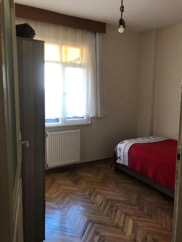 ein Schlafzimmer mit einem Bett, einem Fenster und einem Holzboden in der Unterkunft Private Room in Istanbul #21 in Istanbul