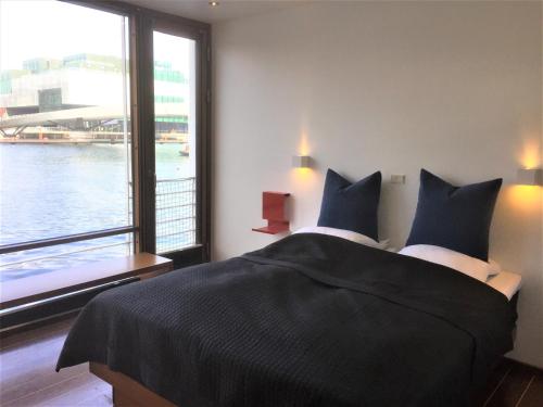 a bedroom with a large bed with a large window at Hotel CPH Living in Copenhagen