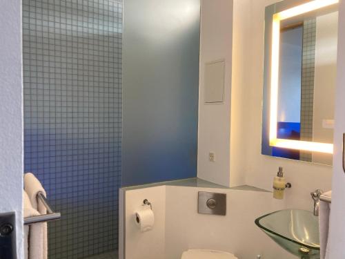 a bathroom with a sink and a toilet and a mirror at Hotel CPH Living in Copenhagen