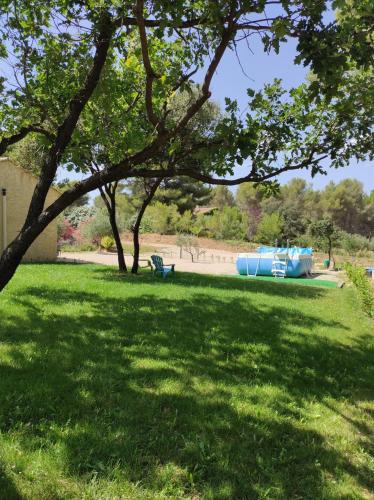 un parc avec un banc dans une prairie dans l'établissement Le temps d une escale, à Lambesc