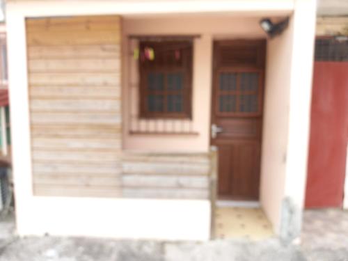a front door of a house with a wooden door at Niky house in Fort-de-France
