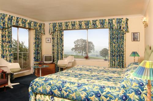 a bedroom with a bed and a large window at Shallowdale House in Helmsley