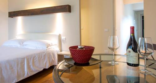 ein Schlafzimmer mit einem Bett und einem Glastisch mit zwei Weinflaschen in der Unterkunft Relais Piazza Signoria in Florenz