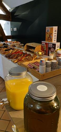 ein Tisch voller Gläser mit Orangensaft und Essen in der Unterkunft Domaine Malar in Guillerval