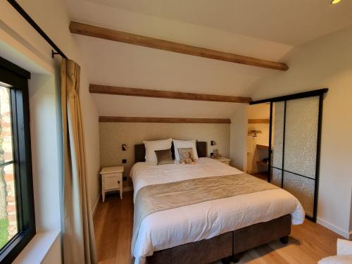 um quarto com uma cama grande e uma janela em De Bogaerd em Lo-Reninge
