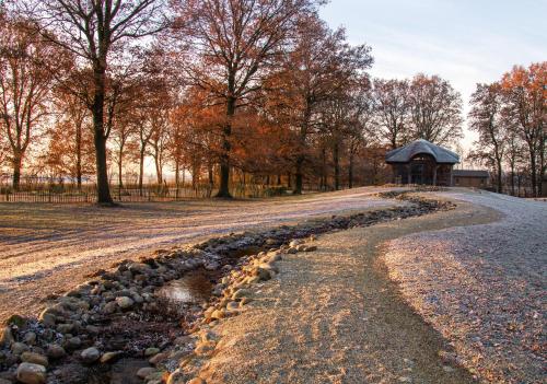 a gravel road leading to a gazebo in a park at Het Hilkensberg Park in Broekhuizen