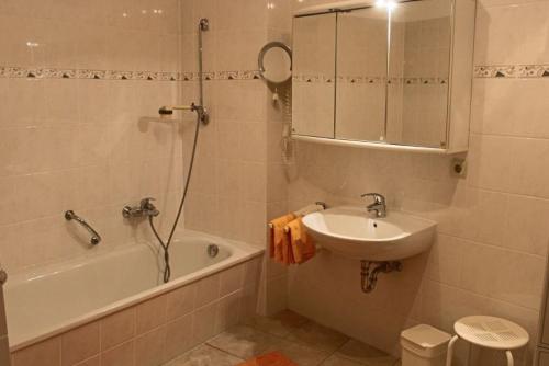een badkamer met een bad, een wastafel en een douche bij Ferienwohnung Backhaus in Goslar