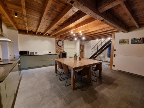 uma cozinha e sala de jantar com uma mesa de madeira em De Bogaerd em Lo-Reninge
