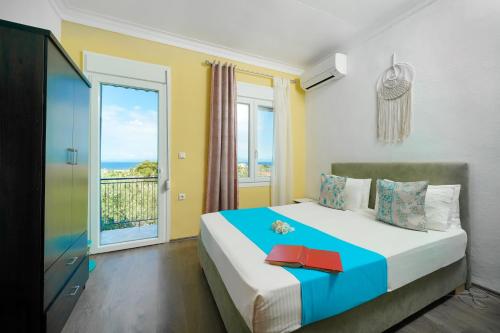 a bedroom with a bed with a view of the ocean at Meji House in Skala Kallirakhis