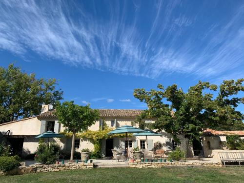 une maison avec un ciel bleu et des arbres dans l'établissement Les Jardins de Sitaara, à Cucuron
